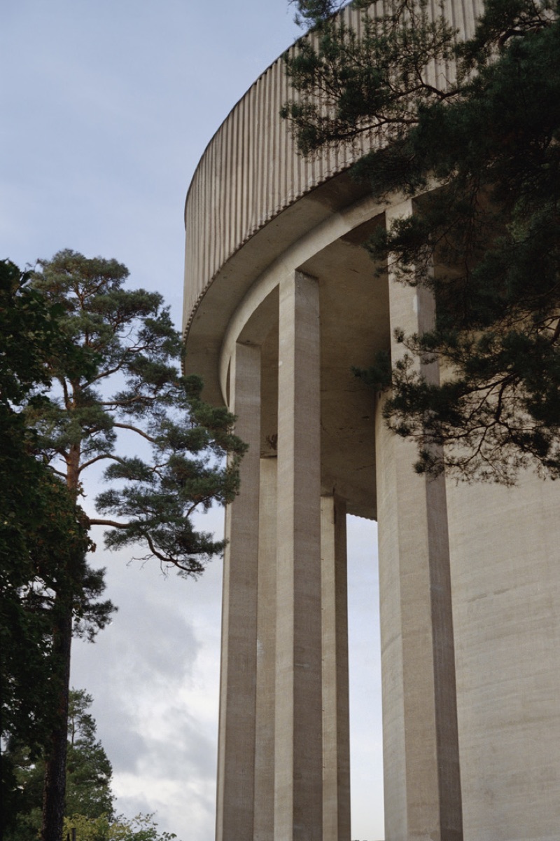 Brutalist concrete water tower among pine trees